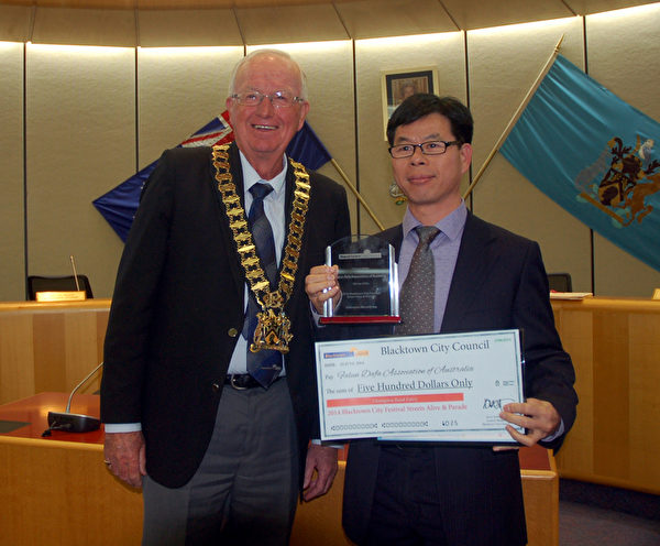 市長羅賓遜先生和法輪功學員代表約翰（John Zhuo）。（明慧網）