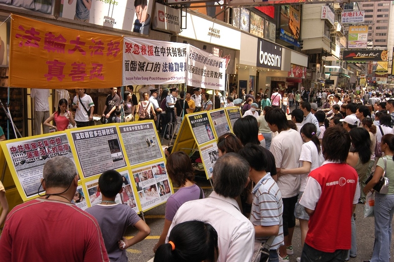 有越来越多民众了解了共产党的邪恶,在全世界范围内掀起了退出中共的热潮。图为香港旺角街头的真相点,令人震撼的迫害酷刑图片,吸引民众停下脚步围观。(李明/大纪元)。
