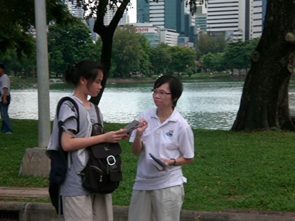 泰国法轮功学员在向游人介绍法轮大法。(大纪元图片) 泰国法轮功学员在向游人介绍法轮大法。(大纪元图片)