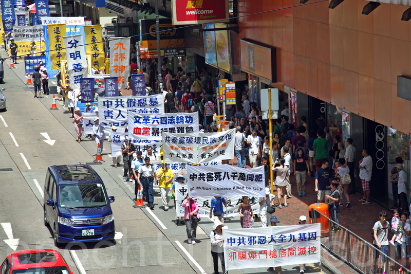 2014年7月19日,逾九百名法輪功學員在香港港島區舉行7.20十五周年反迫害集會遊行,呼籲各界制止中共迫害法輪功。隊伍從北角英皇道出發,途徑多個鬧市區抵達政府總部,吸引眾多中港民眾和遊客駐足觀看。(潘在殊/大紀元)