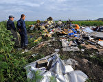 2014年7月19日，烏克蘭Rassipnoe村，烏克蘭國家緊急服務的人員查看馬來西亞航空公司飛行MH17的殘骸。（AFP PHOTO / DOMINIQUE FAGET）