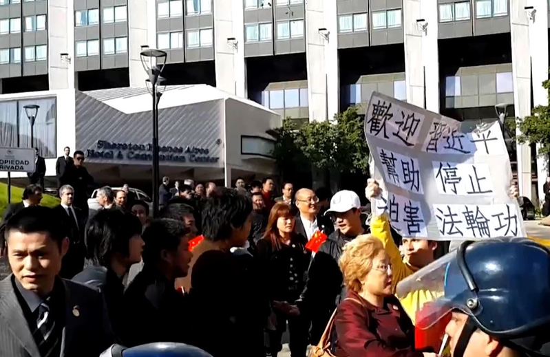 7月18日,中共駐阿根廷使館組織指使惡徒搶奪、損毀在習近平下榻酒店外請愿的阿根廷法轮功学员打出的紙板和橫幅。(大紀元)