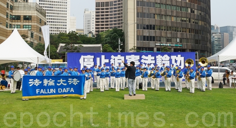 7月20日,來自韓國各地的近千名法輪功學員與韓國各界人士在首爾廣場舉行集會,紀念法輪功反迫害15週年。呼籲解體中共、結束迫害、法辦元凶。圖為由法輪功員組成的天國樂團現場演奏。(金國煥/大紀元)
