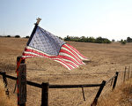 2014年8月8日，加州一個已經播種的農場飄著一面美國國旗，因為持續的乾旱，加州大部份農戶開始從種植小麥、玉米和棉花轉為種植經濟價值更高的杏仁、開心果和釀酒葡萄等。 （Justin Sullivan/Getty Images）