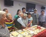 法拉盛永康老人中心8月13日中午笑语喧哗，耆老们齐聚一堂，为8月份过生日的老人家送上祝福。任柏年（后排右三）也带着华埠饼屋捐赠的寿桃前来看望。（陈晓天/大纪元）