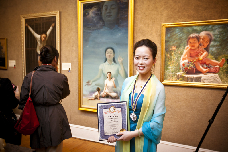 2011年第三屆全世界華人人物寫實油畫大賽金獎得主陳肖平在畫作前留影。(愛德華/大紀元)