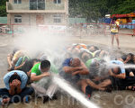 华人民主书院9月7日演练模拟香港警方出动水炮对占中进行清场，超过40名占中“死士”参加，表达为民主不惜公民抗命的牺牲决心。
（蔡雯文／大纪元）