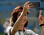英国专家表示，以智能手机拍出完美自拍照的诀窍，就是要让镜头尽量靠近自己，同时要注意光线明暗。图为一名女子在自拍。（Photo by PATRIK STOLLARZ / AFP）