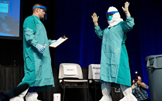 10月21日，紐約市上千名醫保人員在賈維茨會展中心接受埃博拉培訓和動員。圖為培訓中示範如何穿戴防護設備。（州長辦公室提供）