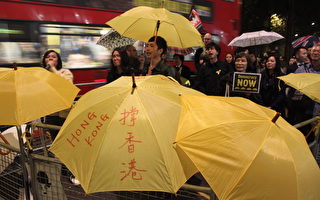 10月30日晚，近200位各界居英港人，包括來自大陸的華人，在香港財政司司長曾俊華，於倫敦梅菲爾出席香港貿易發展局週年晚宴的近四小時內，在會場外高舉雨傘、高呼口號表達支持香港真普選訴求。（曹鶯飛/大紀元）