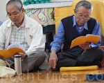 74岁的官老爹(右)修炼法轮功后无病一身轻，每天都做着自己应该做的，活得踏实、有意义。图为官老爹与其他法轮功学员一起集体阅读法轮功书籍。（詹亦菱／大纪元）