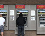 图为客户在富国银行外使用ATM机。(Justin Sullivan/Getty Images)