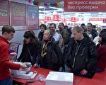 俄罗斯卢布对美元连日暴跌，再次引发俄罗斯民众对通货膨胀以及金融危机的担忧。为了避险，开始抢购大额商品，并疯狂换汇。图为2014年12月15日俄罗斯民众在莫斯科市中心的商场排队等候结账。(KIRILL KUDRYAVTSEV/AFP/Getty Images)