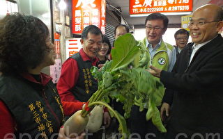 前民進黨主席蘇貞昌(右)11日走訪台中第三市場，為綠營候選人黃國書(中)拉抬聲勢，接受民眾「好彩頭」祝賀。（黃玉燕/大紀元）