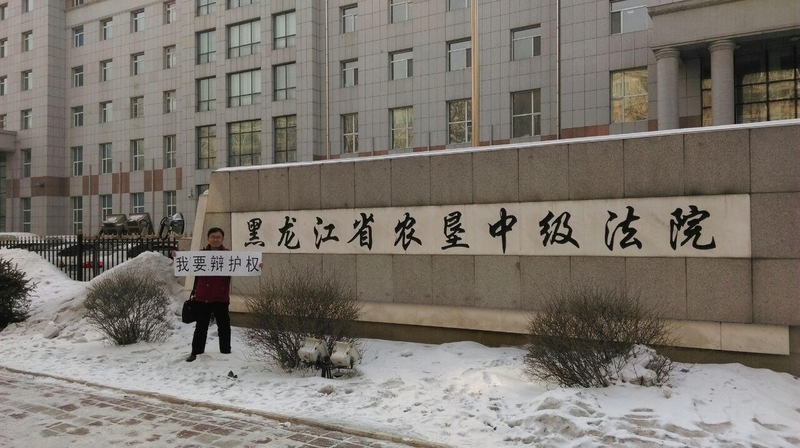 20日,代理律師張維玉與陳智勇律師前往黑龙江高級法院進行控告,圖為陳智勇律師高院外舉牌(大紀元資料室)