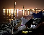 羅馬天主教教宗方濟各訪問菲律賓期間，馬尼拉街友被政府送到海邊「渡假」。圖為1月24日，一名街友睡在馬尼拉灣岸邊。 （NOEL CELIS/AFP）