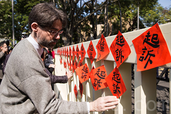 太陽花學運被起訴的部分當事人、義務律師、民間團體等人12日到行政院外抗議檢方濫訴,國際特赦組織台灣分會祕書長唐博偉(Bo Tedards) 在行政院門口貼上「起訴」的春聯。(陳柏州/大紀元) 太陽花學運被起訴的部分當事人、義務律師、民間團體等人12日到行政院外抗議檢方濫訴,國際特赦組織台灣分會祕書長唐博偉(Bo Tedards) 在行政院門口貼上「起訴」的春聯。(陳柏州/大紀元)