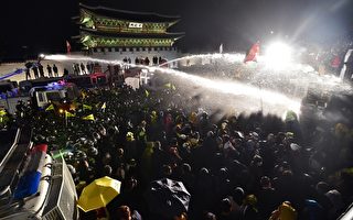 韩国警方以强力水柱驱离前往总统府抗议的群众。(JUNG YEON-JE/AFP)