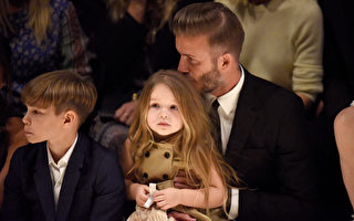贝克汉抱着女儿看秀，还不时闻头发、亲亲，展现满满的父爱。（Jeff Vespa/Getty Images for Burberry）