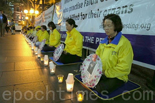 部分澳洲纽省法轮功修炼团体的成员在悉尼市中心的乔治街（George St）举行烛光集会。（摄影何蔚/大纪元）