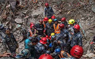 救难队冒着倾盆大雨，持续在尼泊尔强震瓦砾堆中寻找幸存者，但机会愈来愈渺茫。图为30日，搜救队在加德满都倒塌的宾馆瓦砾堆中搜寻幸存者。（Omar Havana/Getty Images）