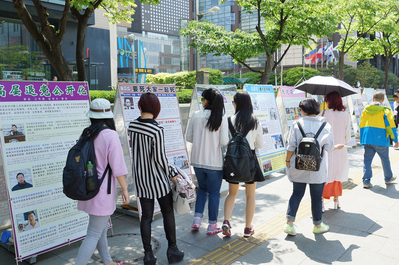 2015年5月10日,韓國慶祝第16屆「5.13世界法輪大法日」及法輪大法洪傳23週年。過往遊客關注。(金國煥/大紀元)