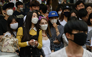 南韓官方今天（8日）通報第6例MERS死亡病例及23起新增確診病例，
其中包括一名16歲的高中生，是目前最年輕的MERS患者。
目前南韓MERS確診病例總數升至87例。圖為首爾街上許多人紛紛戴上口罩，以防感染MERS病毒。（AFP PHOTO / Ed Jones）