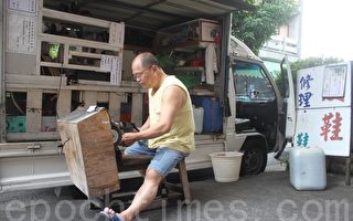 修鞋老師傅楊啟澤在小發財車工作室為客戶守護好鞋。（林萌騫/大紀元）