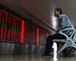 2015年7月10日，一位中国股民在北京一家证卷公司观看股市走势。（GREG BAKER/AFP/Getty Images)
