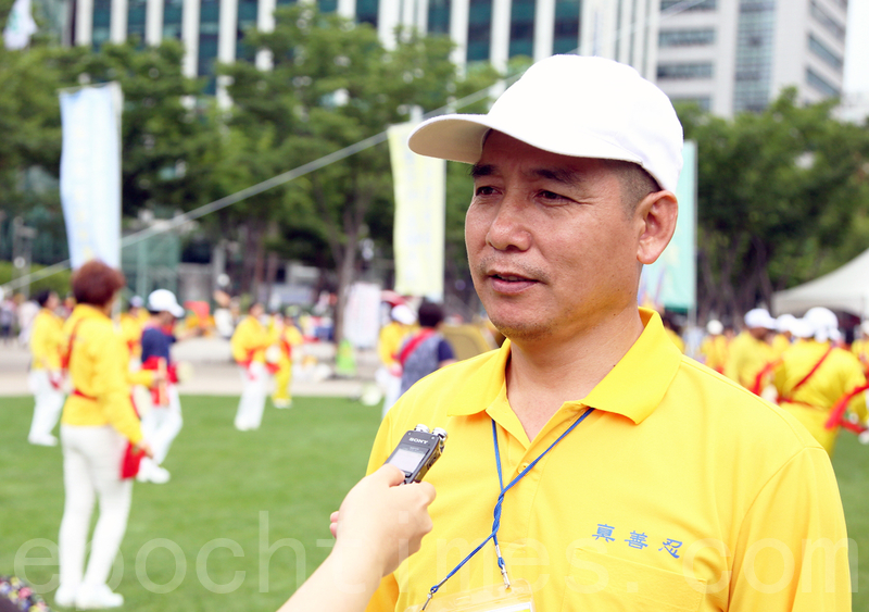 7月20日,韓國法輪功學員在首爾廣場舉行「7.20十六週年反迫害」活動。圖為華人法輪功學員張輝接受採訪。(全宇/大紀元)