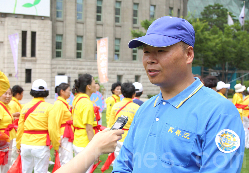7月20日,韓國法輪功學員在首爾廣場舉行「7.20十六週年反迫害」活動。圖為華人法輪功學員王大明接受採訪。(全宇/大紀元)