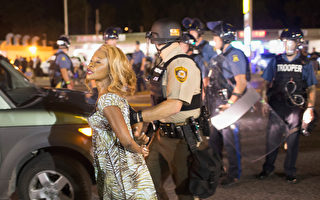 佛格森原本平和的周年游行，10日却因1名男子和警方交火，遭警方严重射伤，引发居民和警方紧张对峙而变调。(Scott Olson/Getty Images)