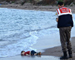2015年9月2日，一艘载有叙利亚难民的船只在海上沉没，一名土耳其警官后来在希腊科斯岛海边发现一个孩子的遗体被冲上岸。后男童被证明为3岁的亚蓝，他的母亲和哥哥也一同遇难，这张照片震撼全球关注难民问题。(DOGAN NEWS AGENCY/AFP)