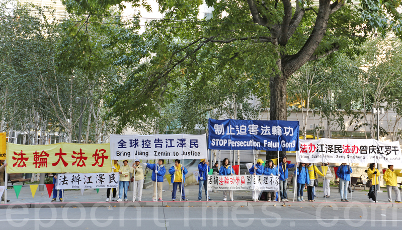 法輪功學員在習近平來訪時的一個街道兩邊展示出的「法辦江澤民 法辦曾慶紅 法辦羅干」等展板。(潔心/大紀元)