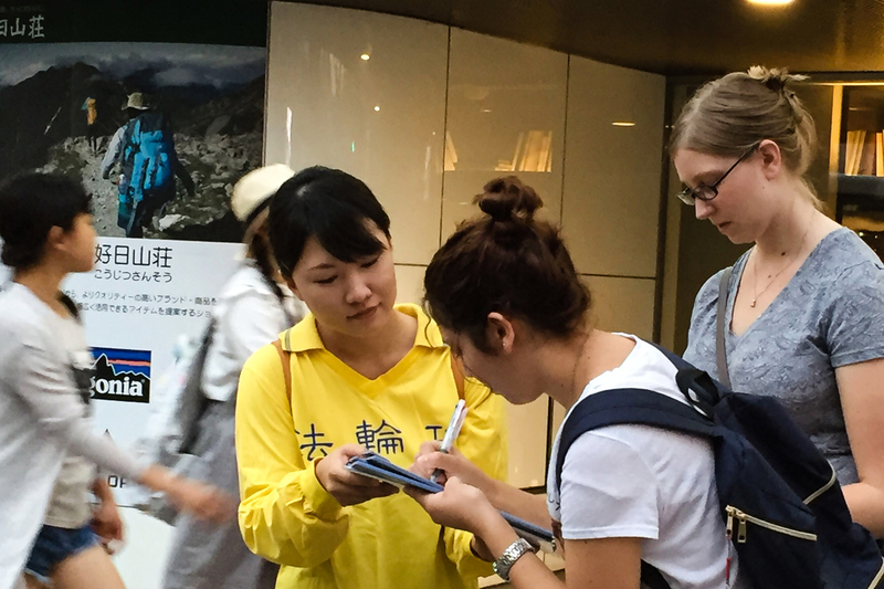 日本各地的法輪功學員在街頭向日本民眾講述法輪功受迫害的真相,聲援控江。 圖為日本熊本縣的法輪功學員在街頭聯署舉報的情景。(大紀元圖片)