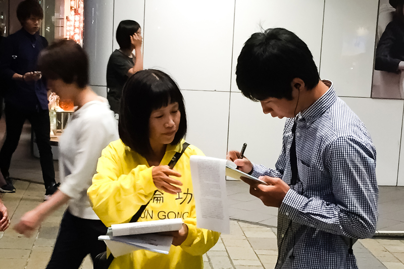 日本各地的法輪功學員在街頭向日本民眾講述法輪功受迫害的真相,聲援控江。圖為日本熊本縣的法輪功學員在街頭聯署舉報的情景。(大紀元圖片)