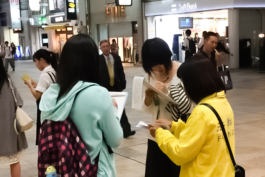 日本各地的法輪功學員在街頭向日本民眾講述法輪功受迫害的真相,聲援控江。圖為日本熊本縣的法輪功學員在街頭聯署舉報的情景。(大紀元圖片)