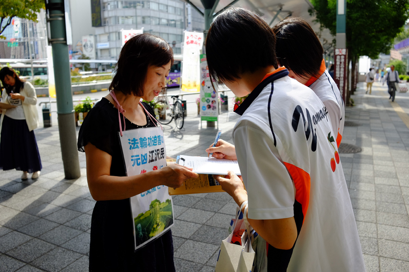 日本各地的法輪功學員在街頭向日本民眾講述法輪功受迫害的真相,聲援控江。圖為日本大阪的法輪功學員在街頭聯署舉報江澤民的情景。(大紀元圖片)
