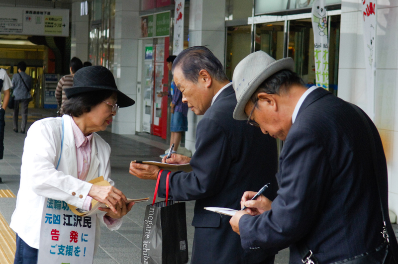 日本各地的法輪功學員在街頭向日本民眾講述法輪功受迫害的真相,聲援控江。 圖為日本大阪的法輪功學員在街頭聯署舉報江澤民的情景景。(大紀元圖片)