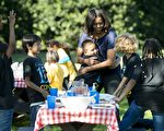 2015年10月6日，華盛頓特區白宮南草坪，美國第一夫人米歇爾·奧巴馬和學童們吃完了從白宮菜園收成做成的蔬菜沙拉後，擁抱了當地的學生。這是白宮廚房花園第二年的秋收。(SAUL LOEB/AFP)