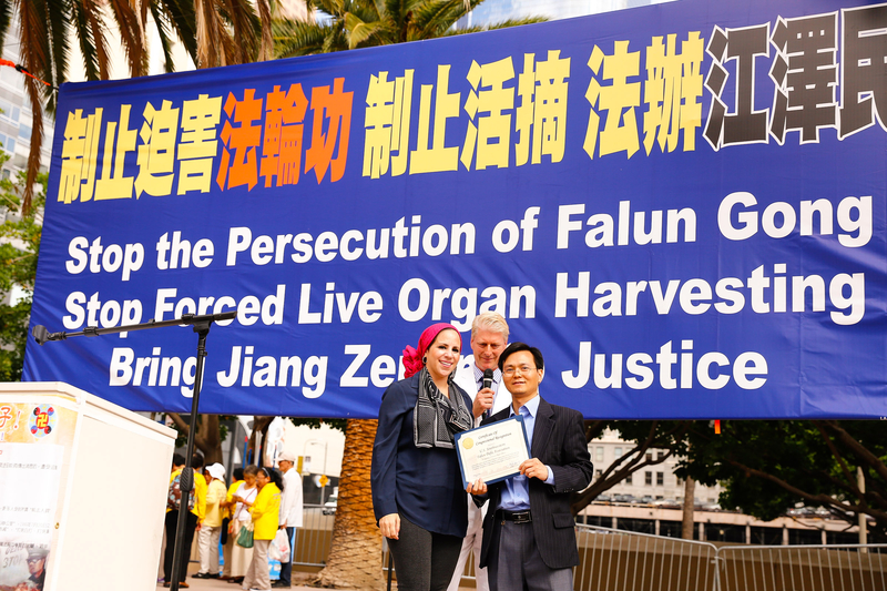 2015年10月15日,全球部分法轮功学员在洛杉矶市中心举行大型集会。图为国会议员洛雷塔‧桑切斯(Loretta Sanchez)社区联络人哈米达(Rida Hamida,左一)来到集会现场颁发褒奖。(戴兵/大纪元)
