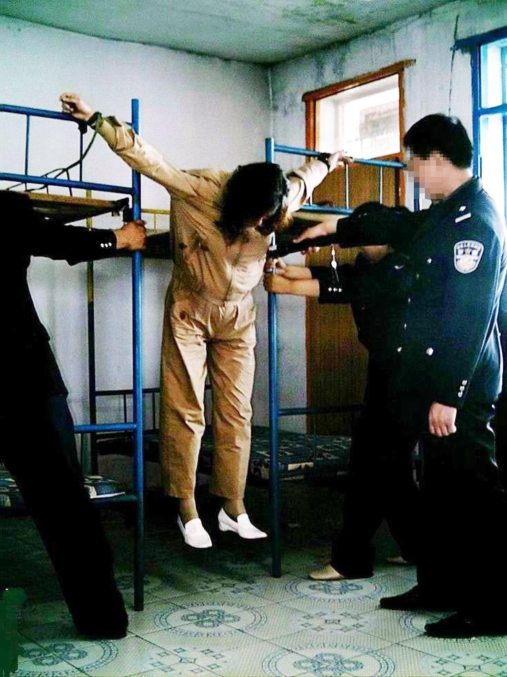 酷刑演示:抻銬(明慧網)