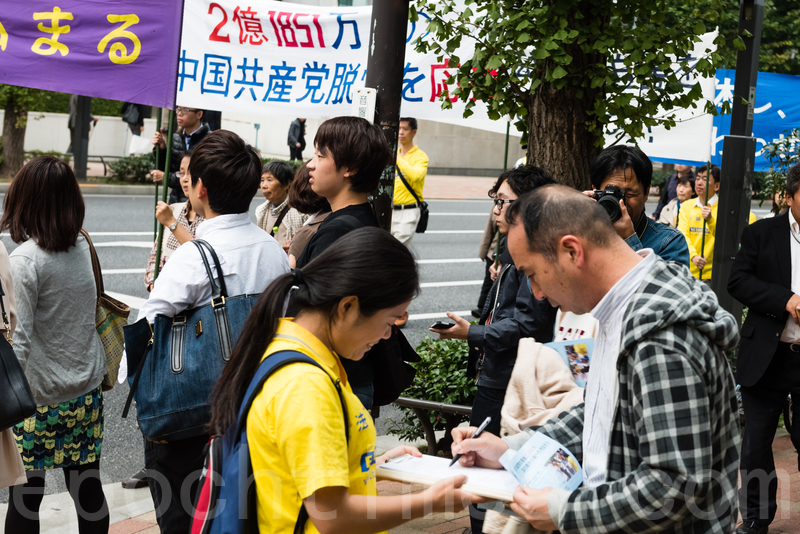 11月7日,日本法輪功學員在東京新宿的商業繁華區舉行遊行,及徵集舉報江澤民的聯署活動。許多日本民眾簽名支持,有中國遊客當場表示退出中共的黨團隊組織。(游沛然/大紀元)