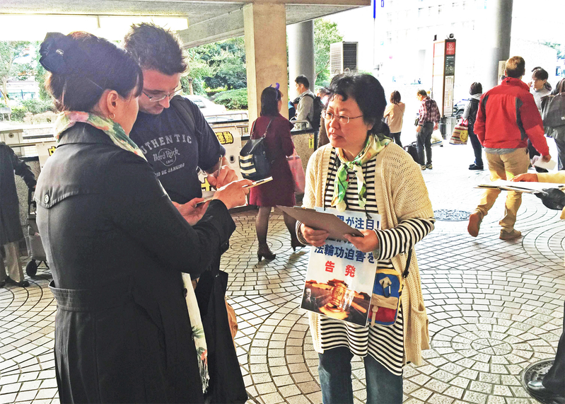 日本各地的法輪功學員在街頭向日本民眾講述法輪功受迫害的真相,聲援控江。圖為東京的法輪功學員在新宿車站進行聯署舉報江澤民活動。(大紀元圖片)