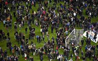 事发后，足球迷们聚集于球场的中心以保安全。 (FRANCK FIFE/AFP/Getty Images)