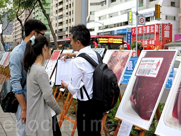 台灣法輪功學員6日向過往民眾徵簽聲援告江大潮,高雄民眾簽名連署舉報迫害元凶江澤民。 (李晴玳/大紀元) 台灣法輪功學員6日向過往民眾徵簽聲援告江大潮,高雄民眾簽名連署舉報迫害元凶江澤民。 (李晴玳/大紀元)
