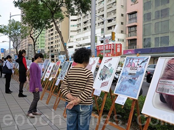 高雄民眾6日觀看反活摘真相圖片。(李晴玳/大紀元) 高雄民眾6日觀看反活摘真相圖片。(李晴玳/大紀元)