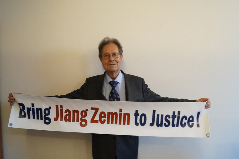 歐洲議會議員克勞斯‧布赫納教授(Prof. Dr. Klaus Buchner)手舉 「法辦江澤民!」的橫幅。(大紀元)