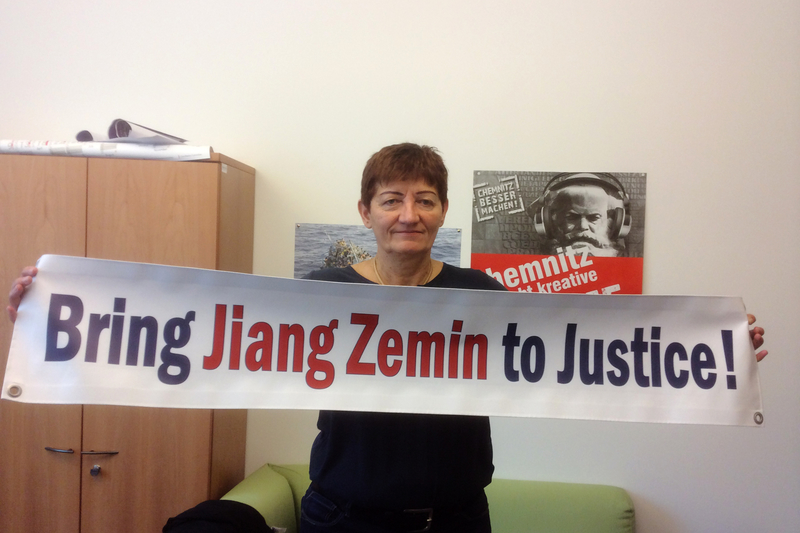 歐洲議會議員科妮莉亞‧恩斯特博士(Dr. Cornelia Ernst)手舉「法辦江澤民!」的橫幅。(大紀元)