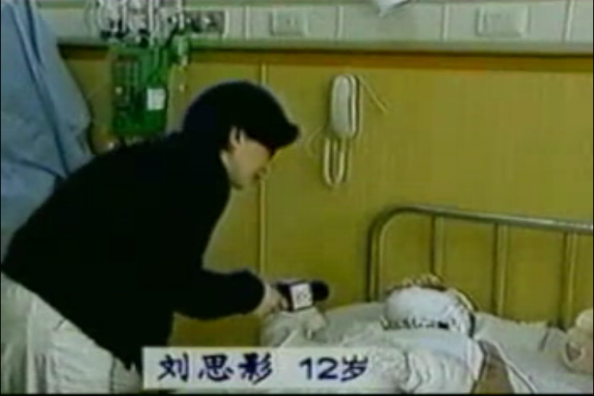中央电视台“天安门自焚案”中的“烧伤病人”全身包裹,记者不穿卫生服,不戴口罩,大胆采访。(视频截图)